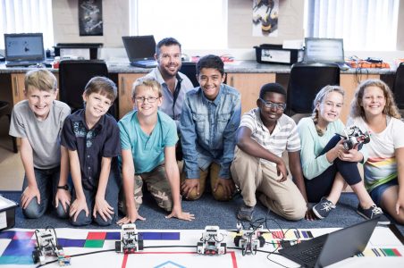 Portrait of smiling kids with teacher in robotics class